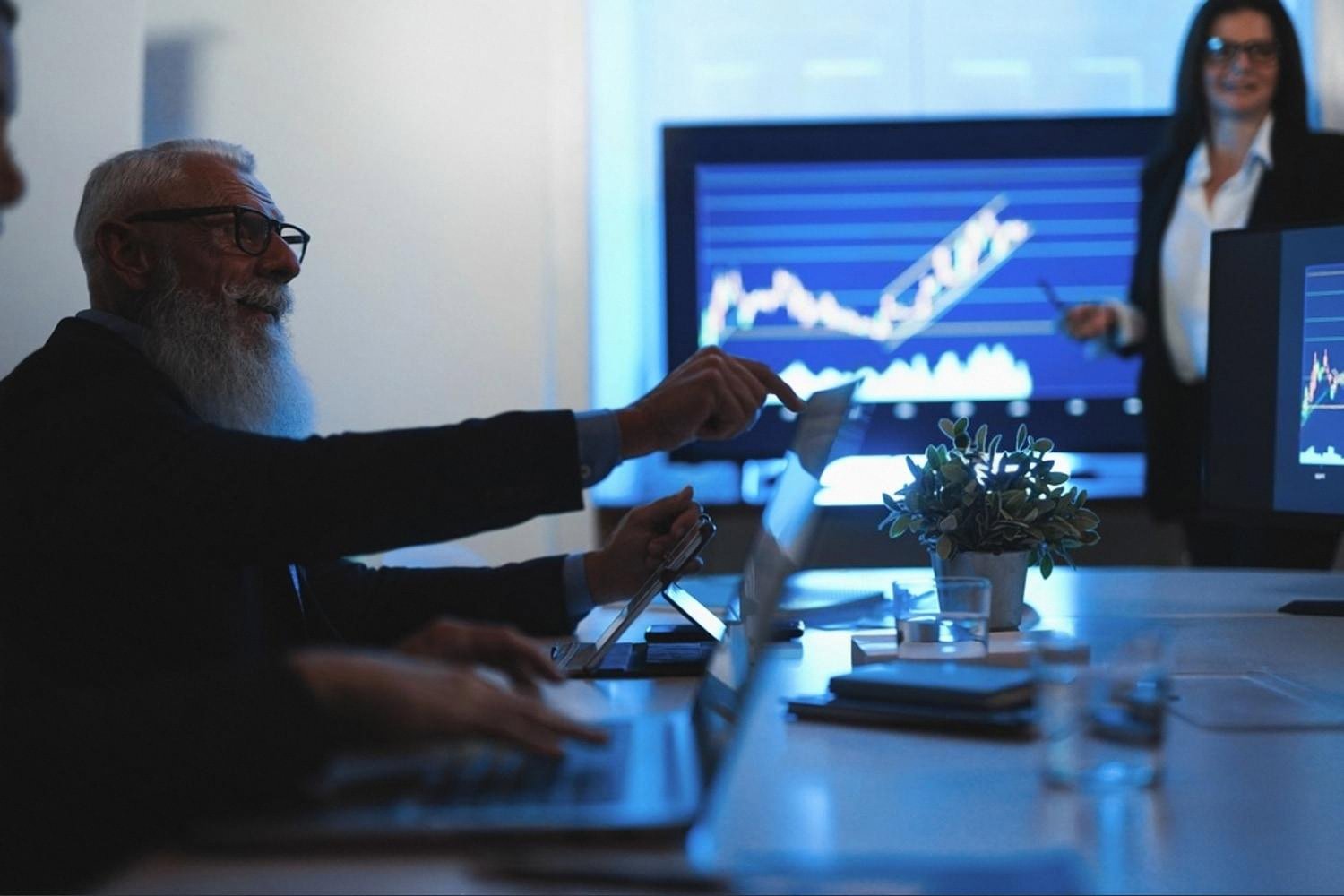 Senior analyst studying financial charts during a Dubai deal review